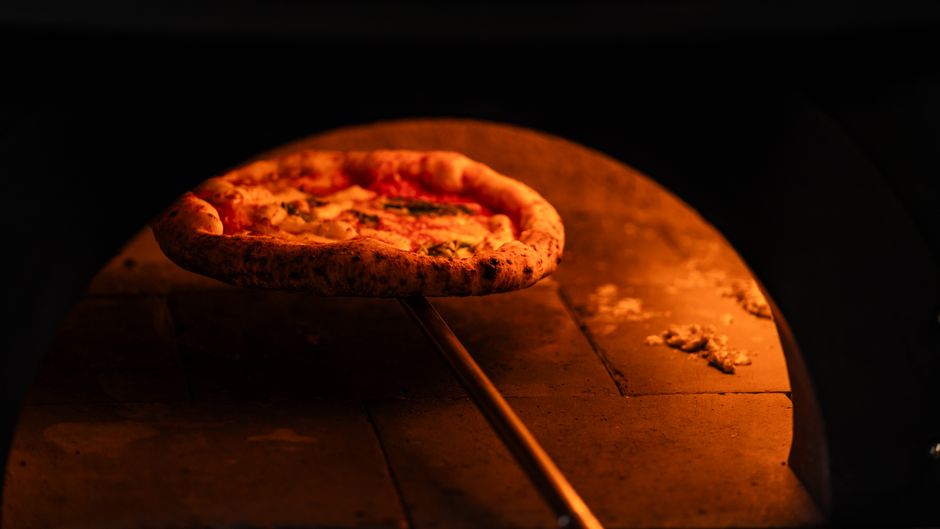 Odun fırınının ağzında pizza